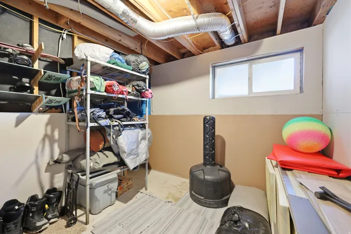 Lower level space featuring exposed ceiling joists and ductwork