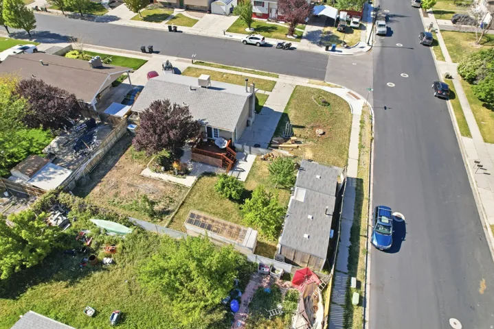 Single-story residence featuring a gray shingle roof, rear wooden deck, and a fenced backyard