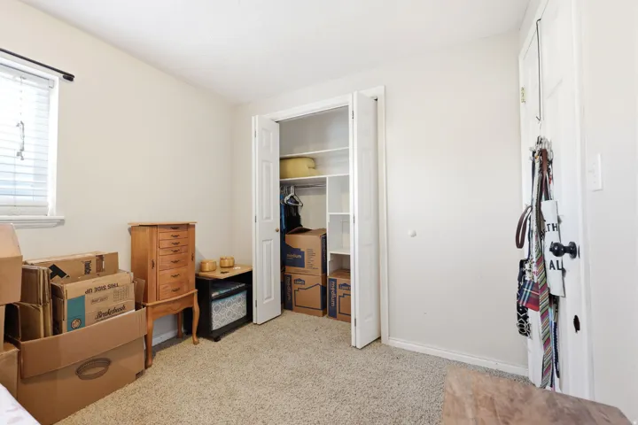 Room featuring neutral wall paint, textured carpeting, and a window with horizontal blinds