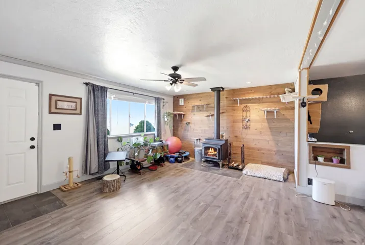 Open concept living space featuring wood-finish flooring and a wood-paneled accent wall