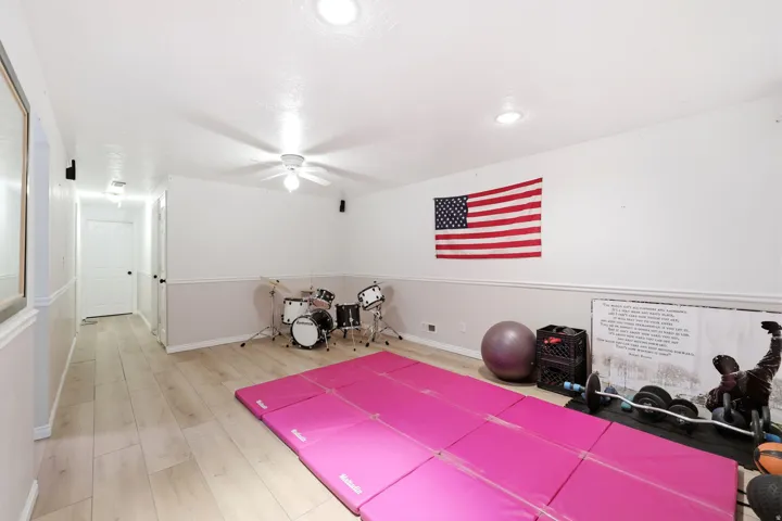 Spacious room with light wood-finish flooring, recessed lighting, and a ceiling fan
