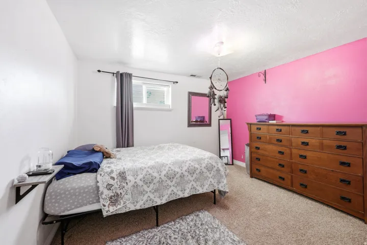 Room featuring carpet flooring, a window with curtain rod, and a built-in wall shelf