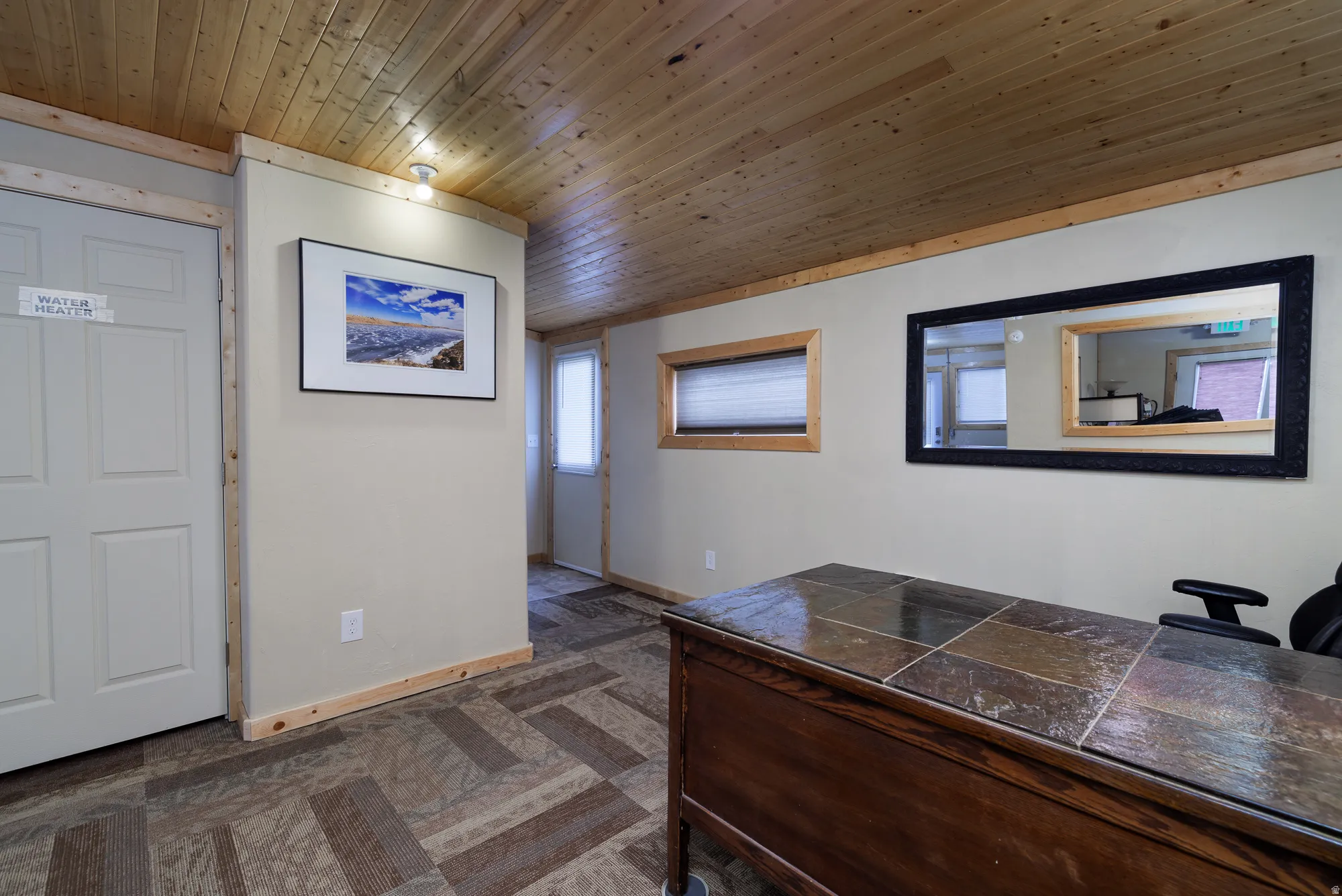 Entry area featuring wood-finish ceiling panels, light-toned walls, and geometric pattern flooring