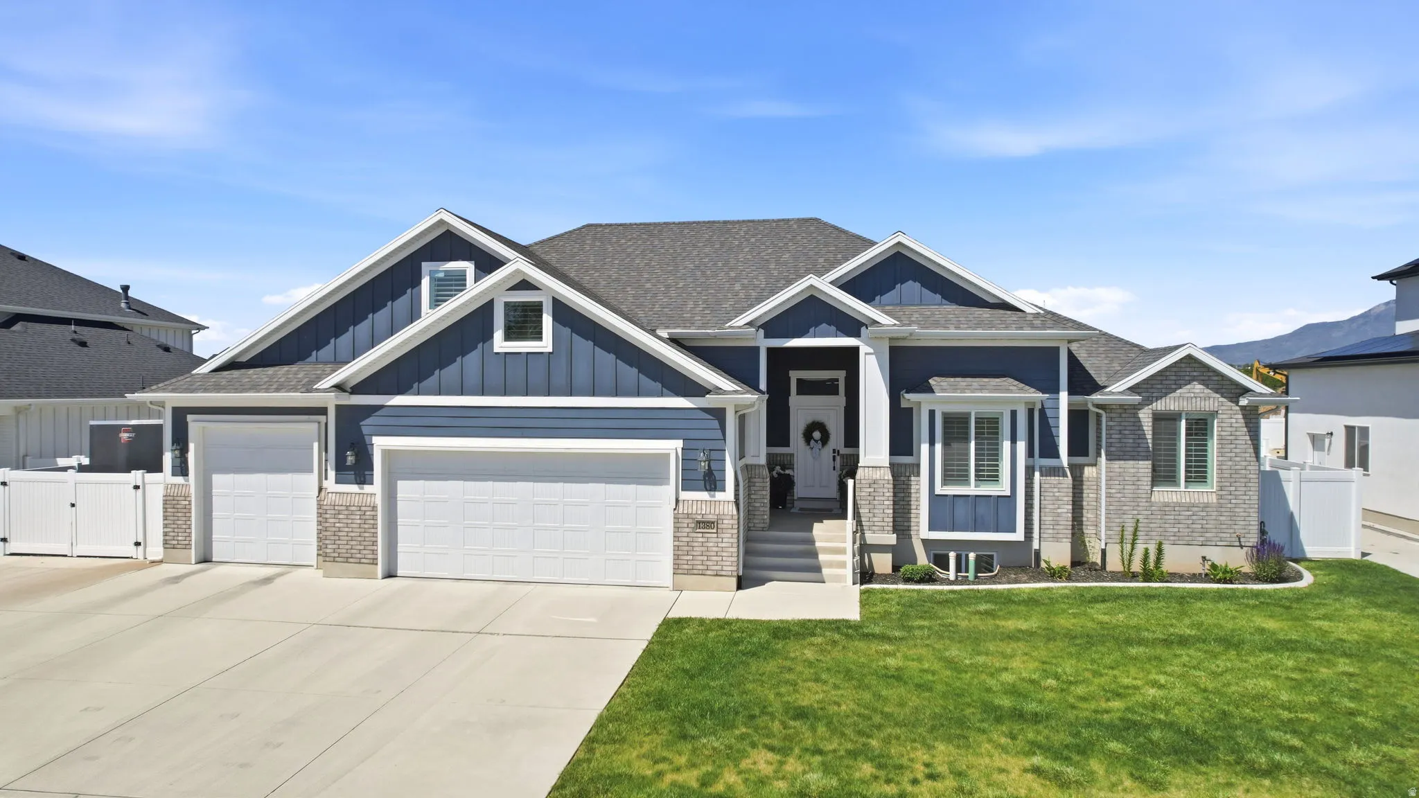 Contemporary exterior featuring a navy blue siding, gray brick accents, and a complementary gray shingle roof
