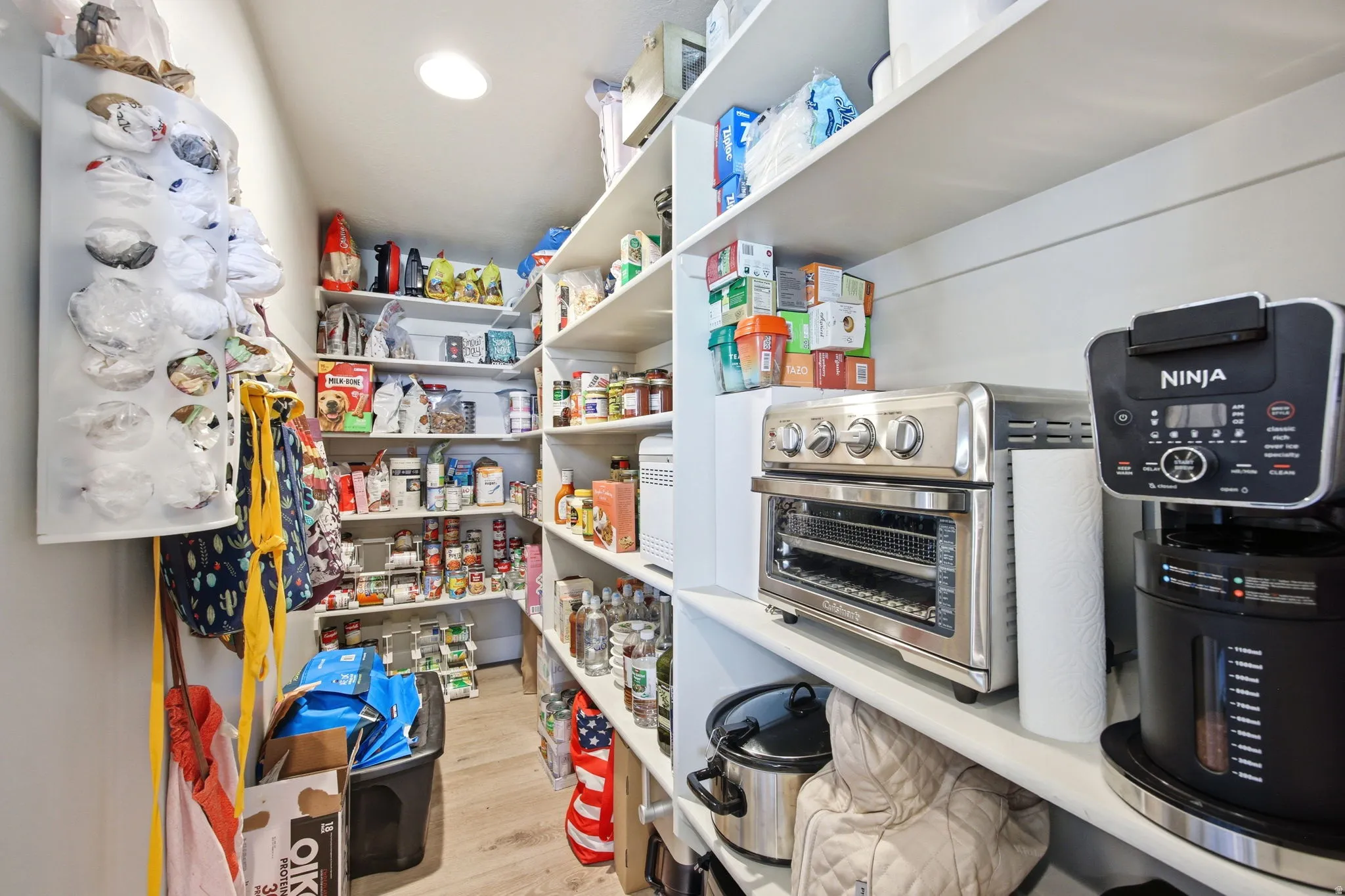 Walk-in pantry featuring extensive white shelving