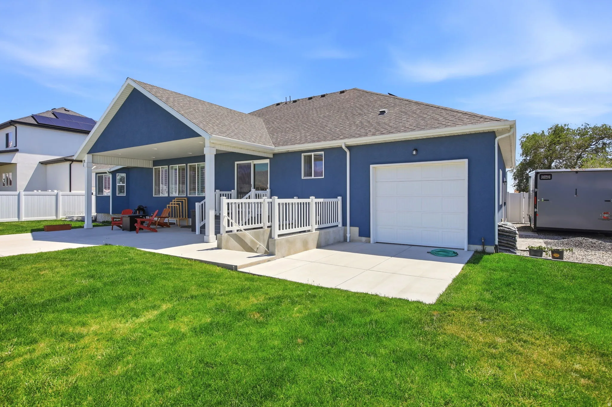 Exterior featuring blue siding, a covered patio, and a two-car garage