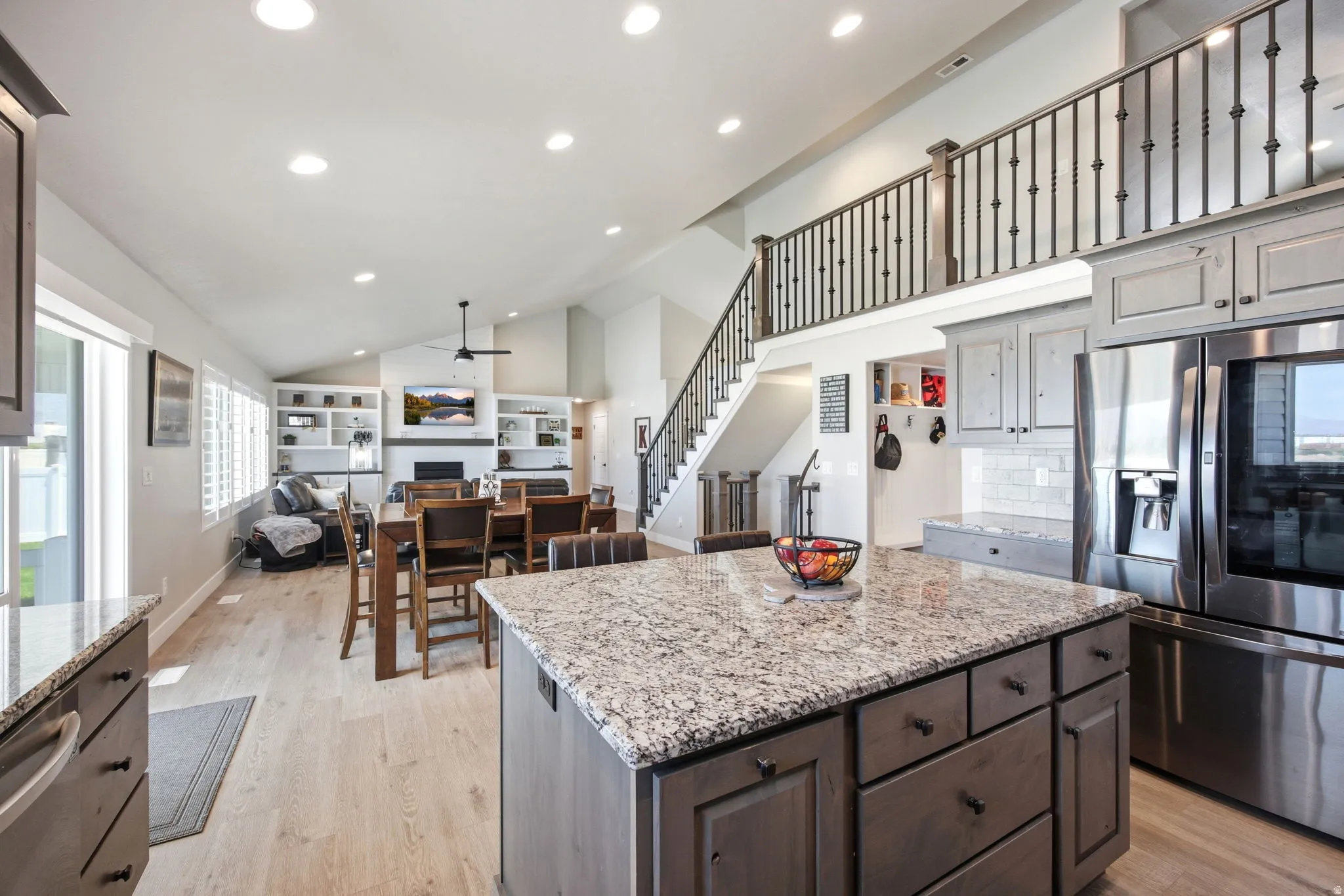 Open-concept living space with a kitchen island featuring a granite-finish countertop and built-in drawers