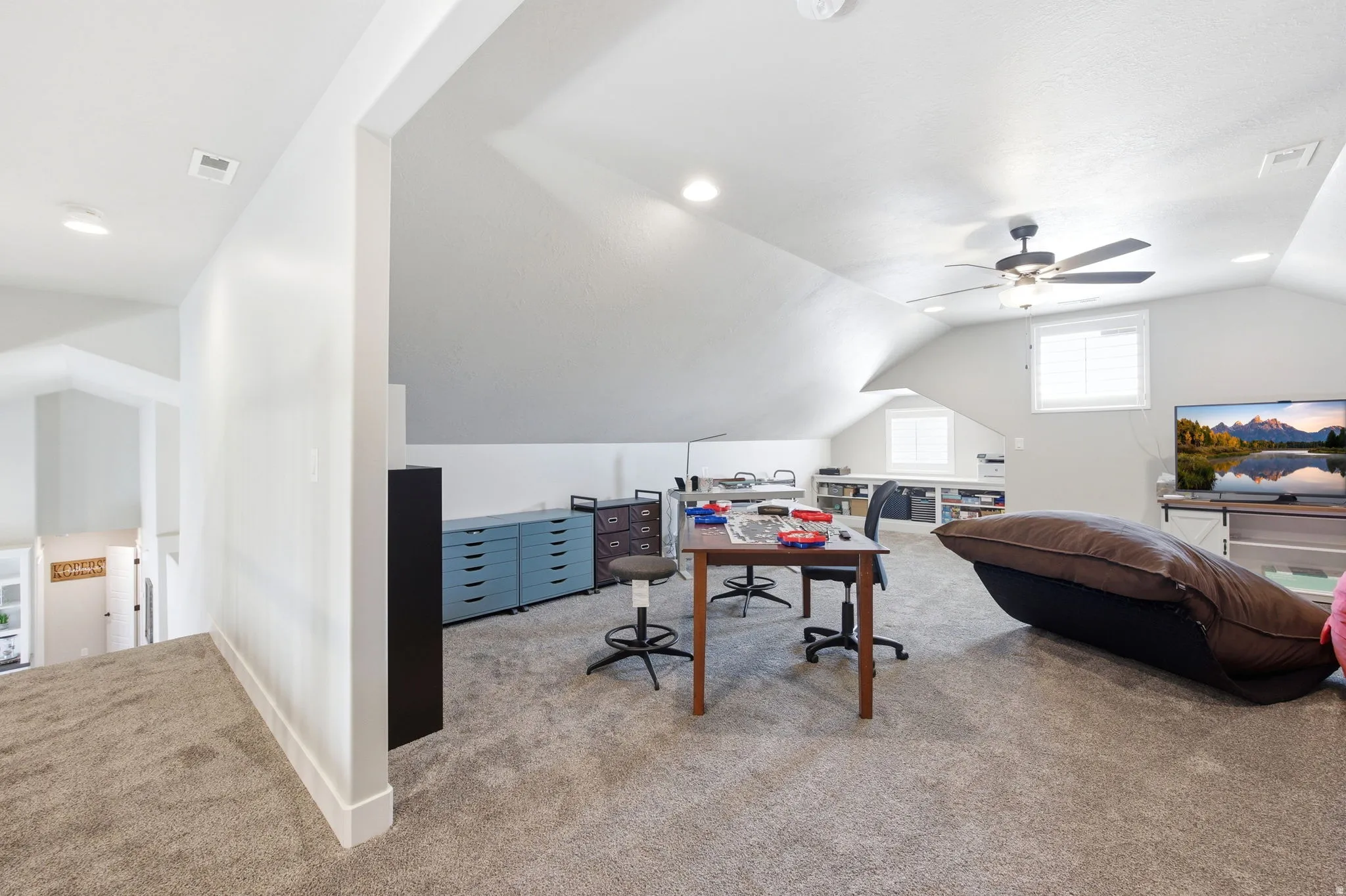 Spacious carpeted bonus room with sloped ceilings and recessed lighting