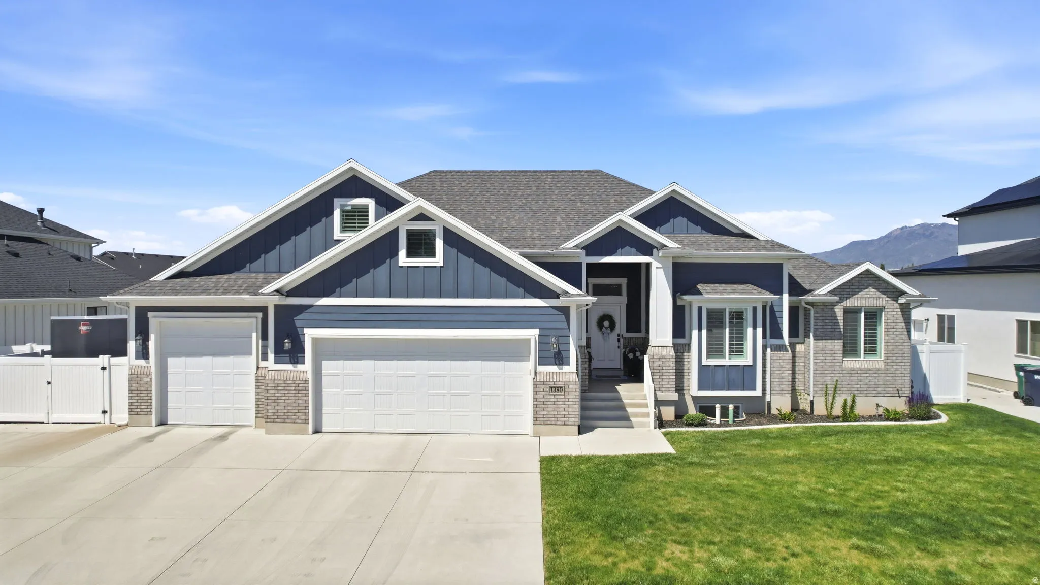 Contemporary residence featuring a two-car garage, an additional single-car garage, and a concrete driveway