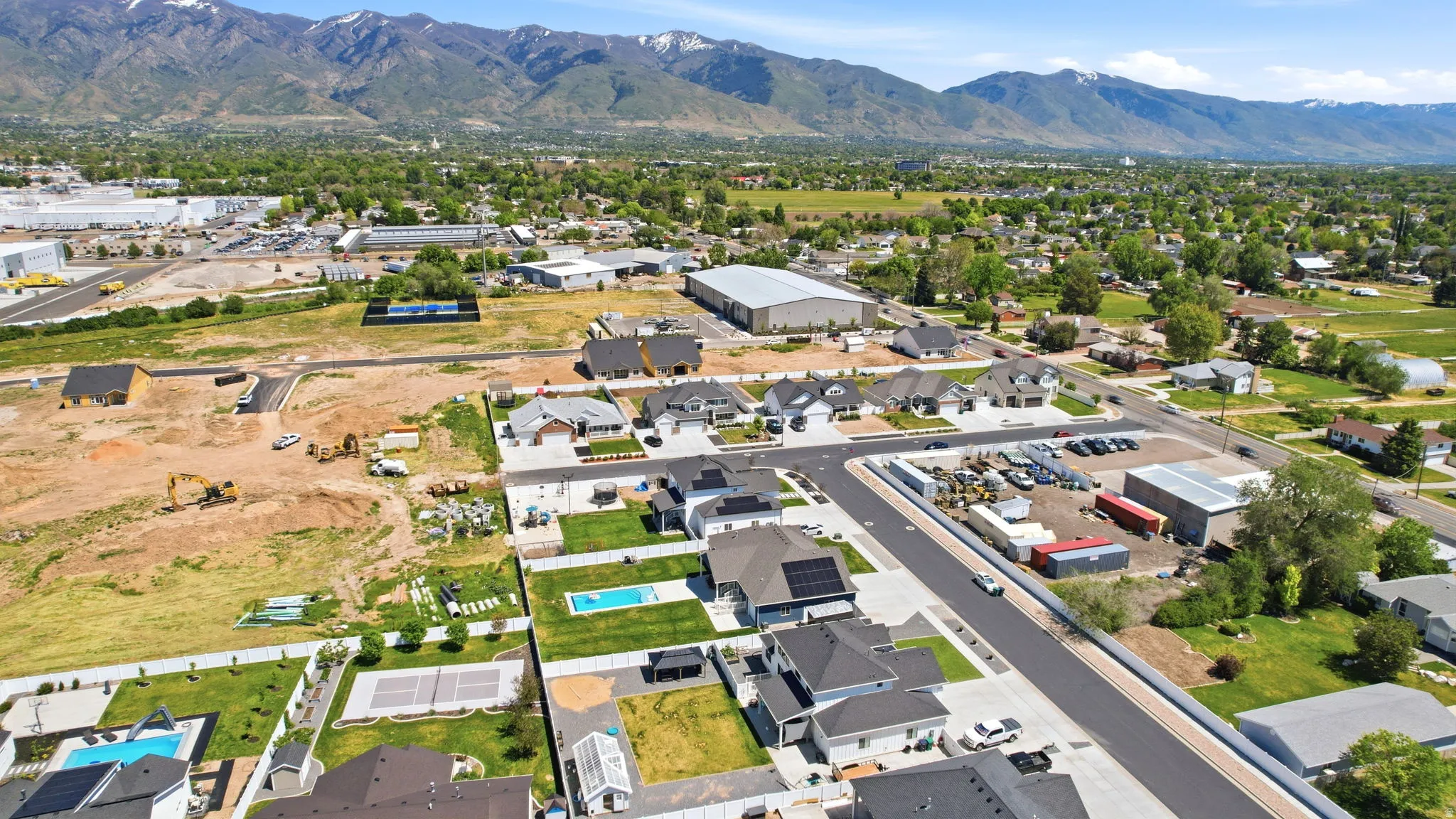 Aerial perspective showcasing a developing residential area with mountainous terrain in the background
