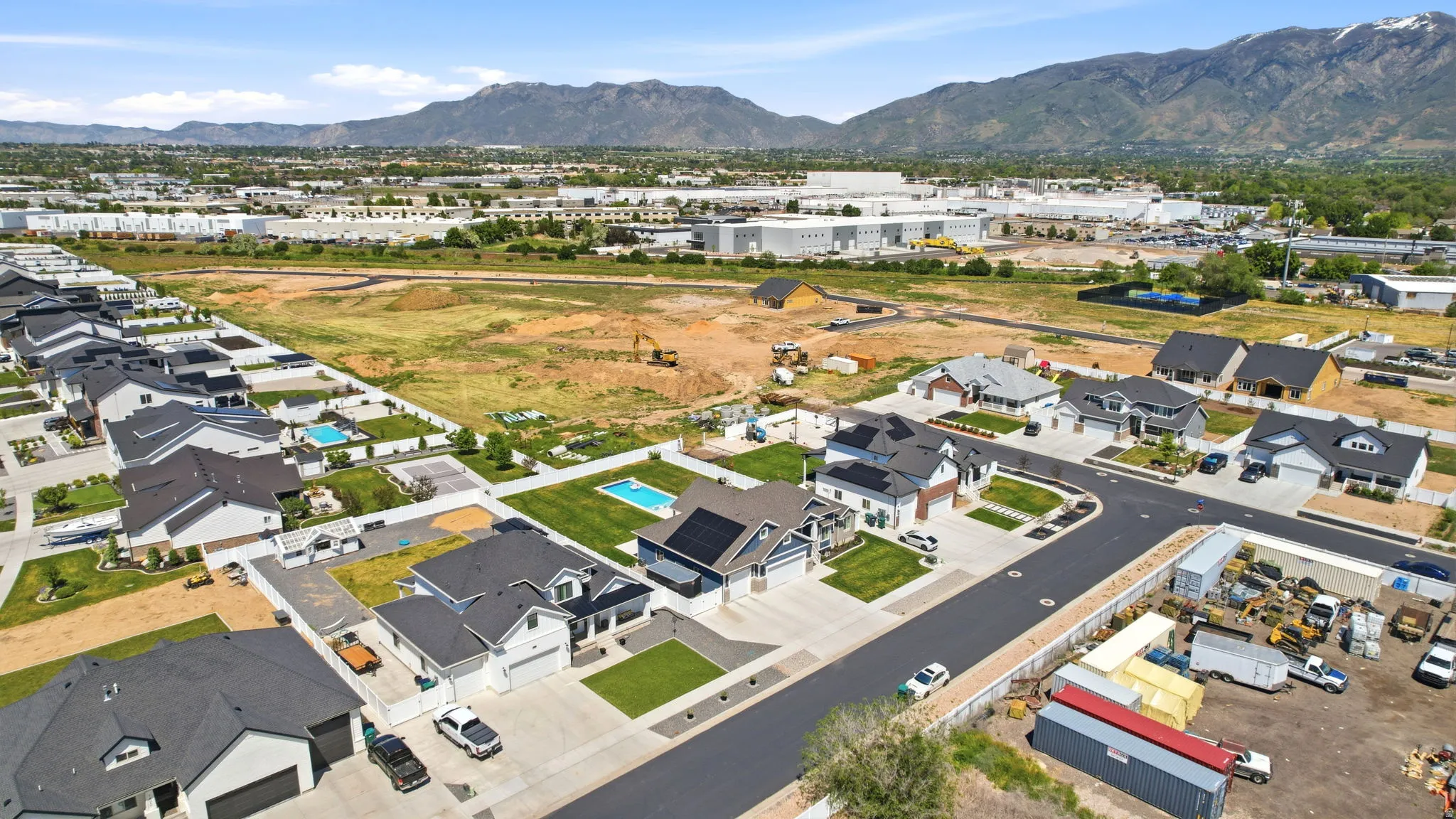 Aerial perspective showcasing a residential development with modern homes, some featuring private swimming pools