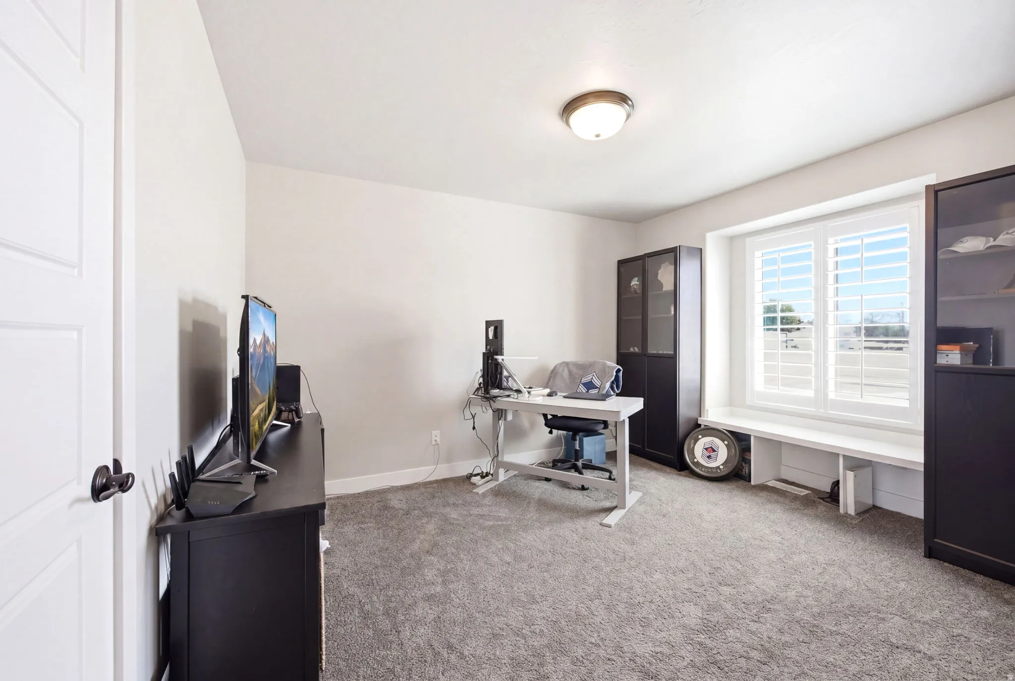 Spacious room featuring neutral-toned walls and grey carpet flooring