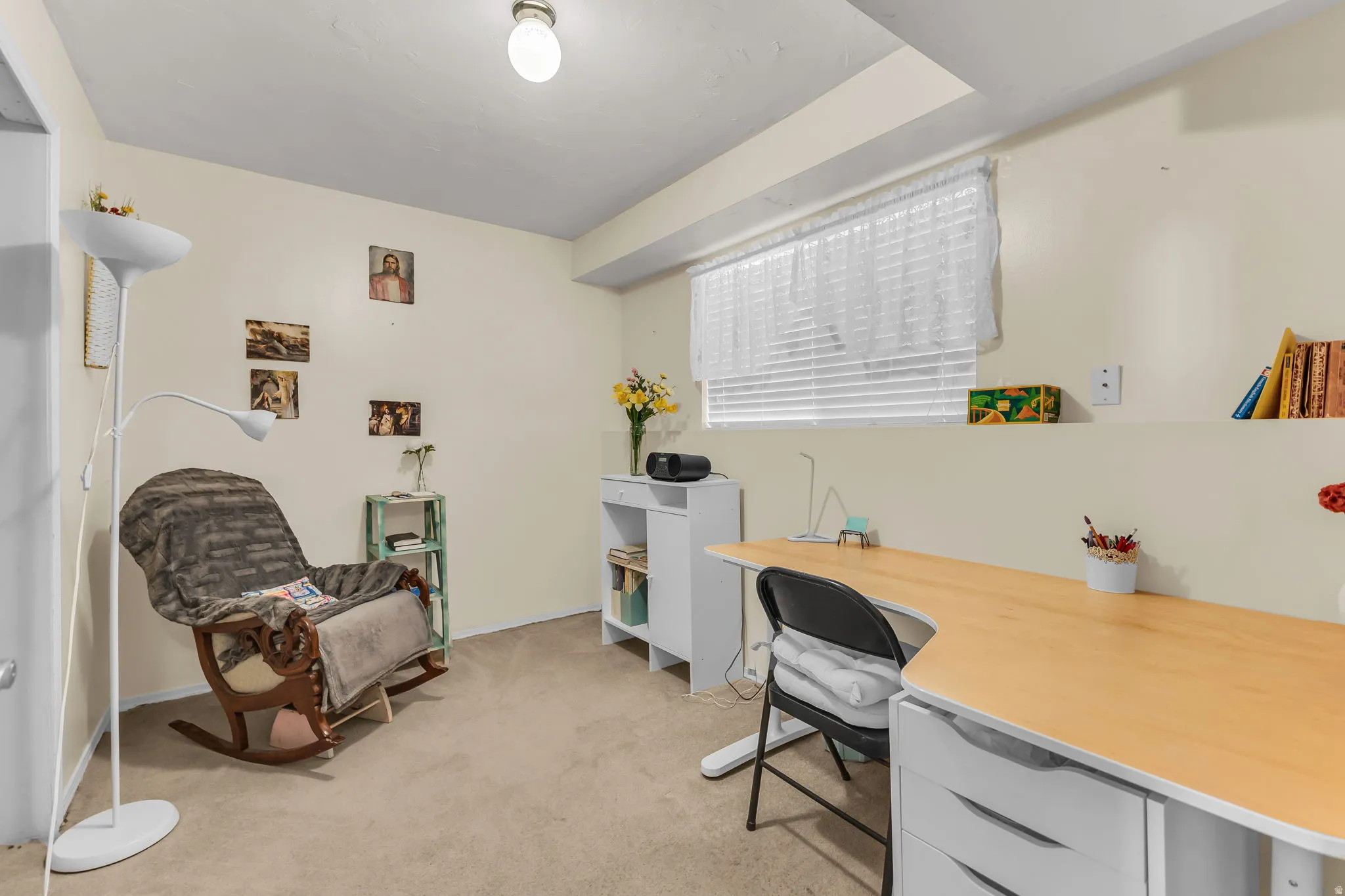 Carpeted room featuring a window with blinds, a built-in shelf, and recessed ceiling elements