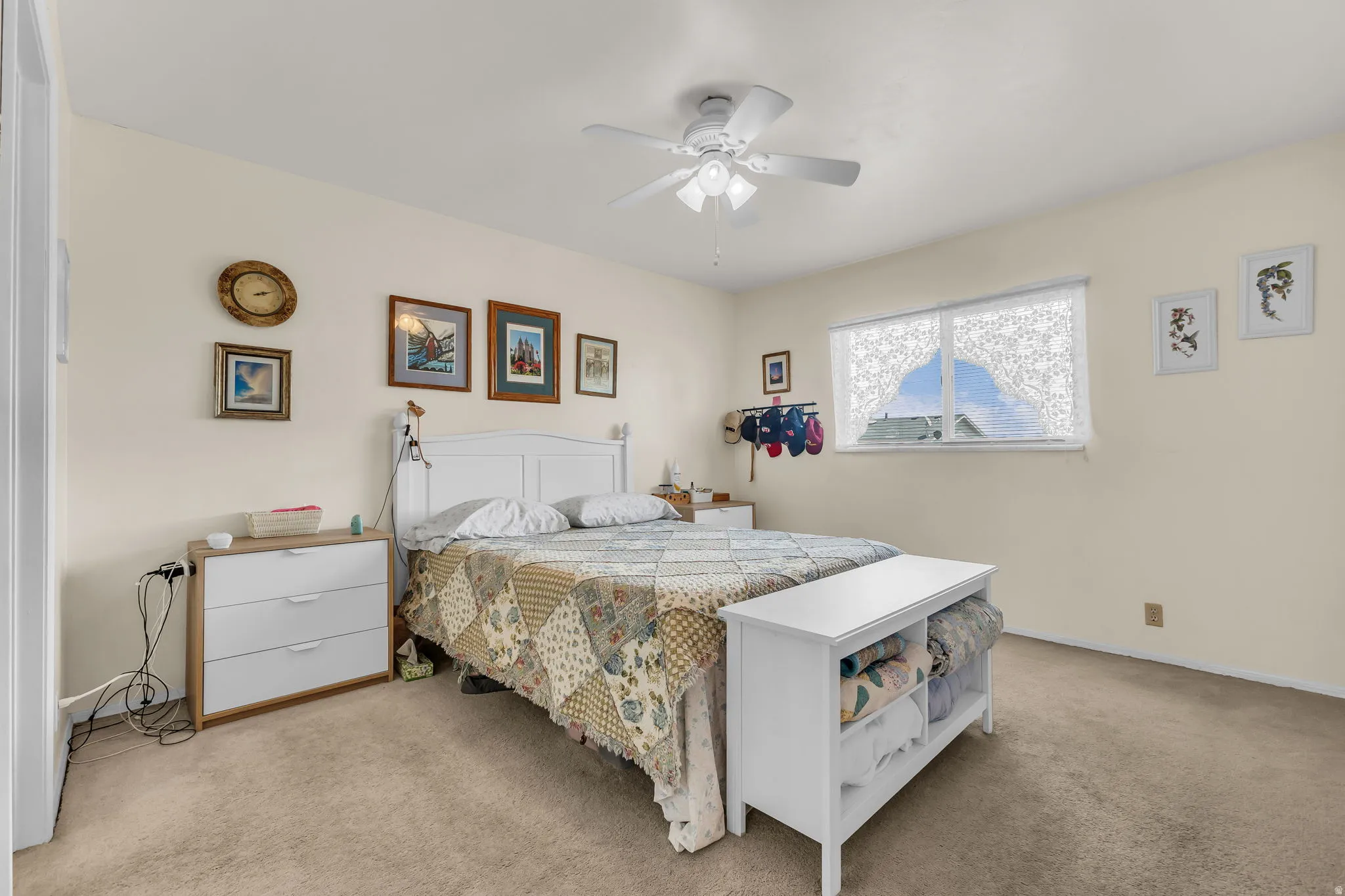 Carpeted bedroom featuring neutral-toned walls and a ceiling fan with integrated lighting