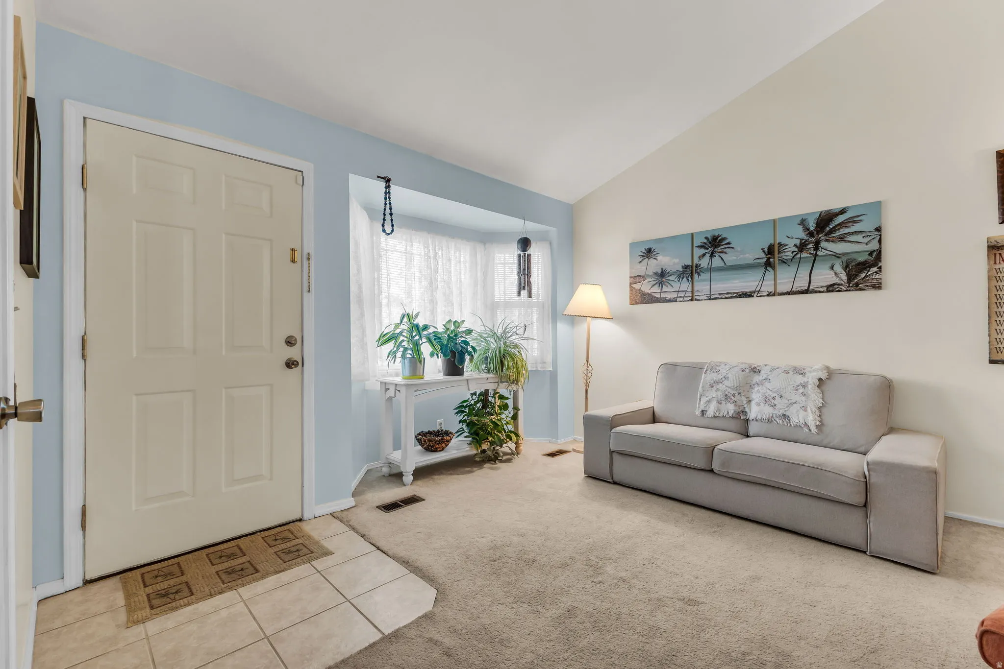 Entryway with a paneled door, ceramic tile flooring, and a bay window featuring sheer white curtains