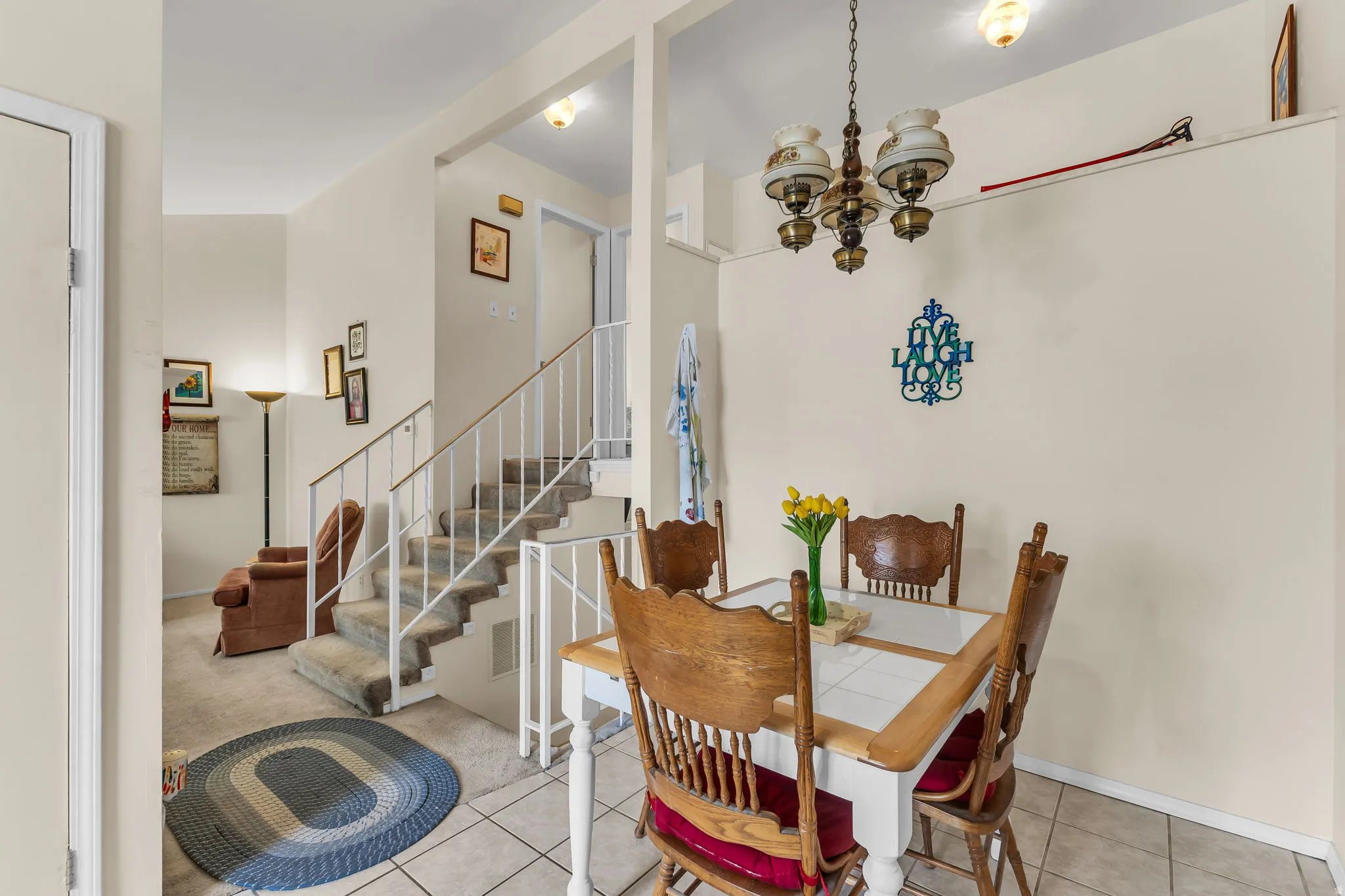 Dining area with tiled flooring, featuring a decorative chandelier and neutral wall tones
