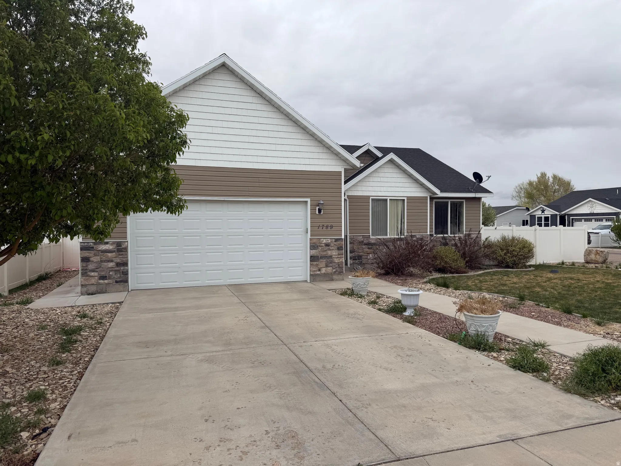 Exterior featuring a two-car garage, concrete driveway, and stone facade accents
