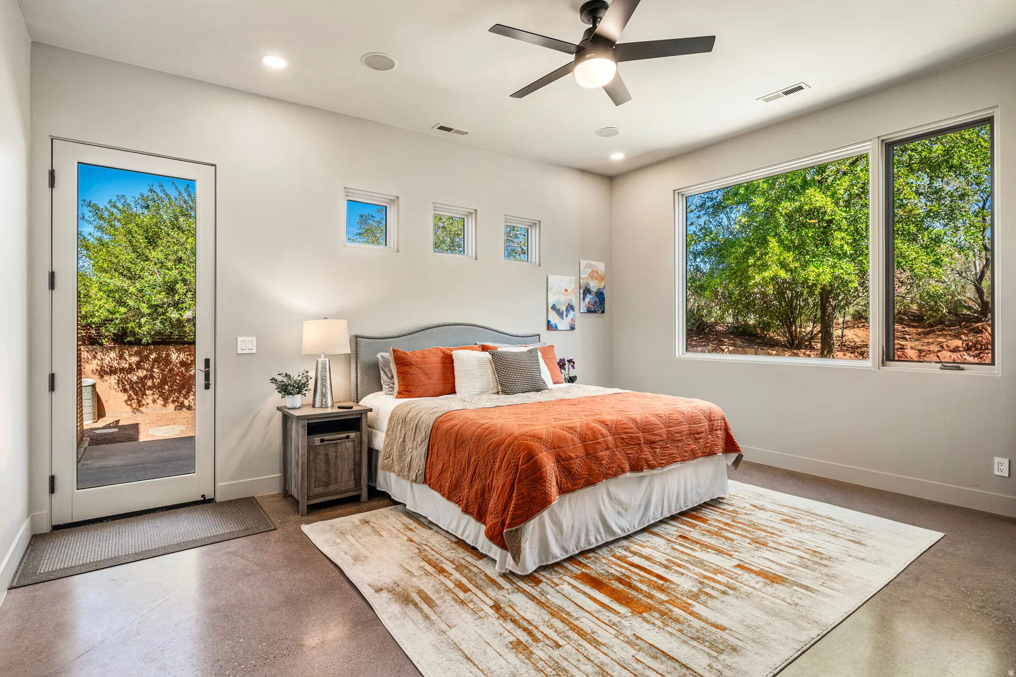 Spacious room featuring polished concrete flooring, a full-lite exterior door, and large picture windows