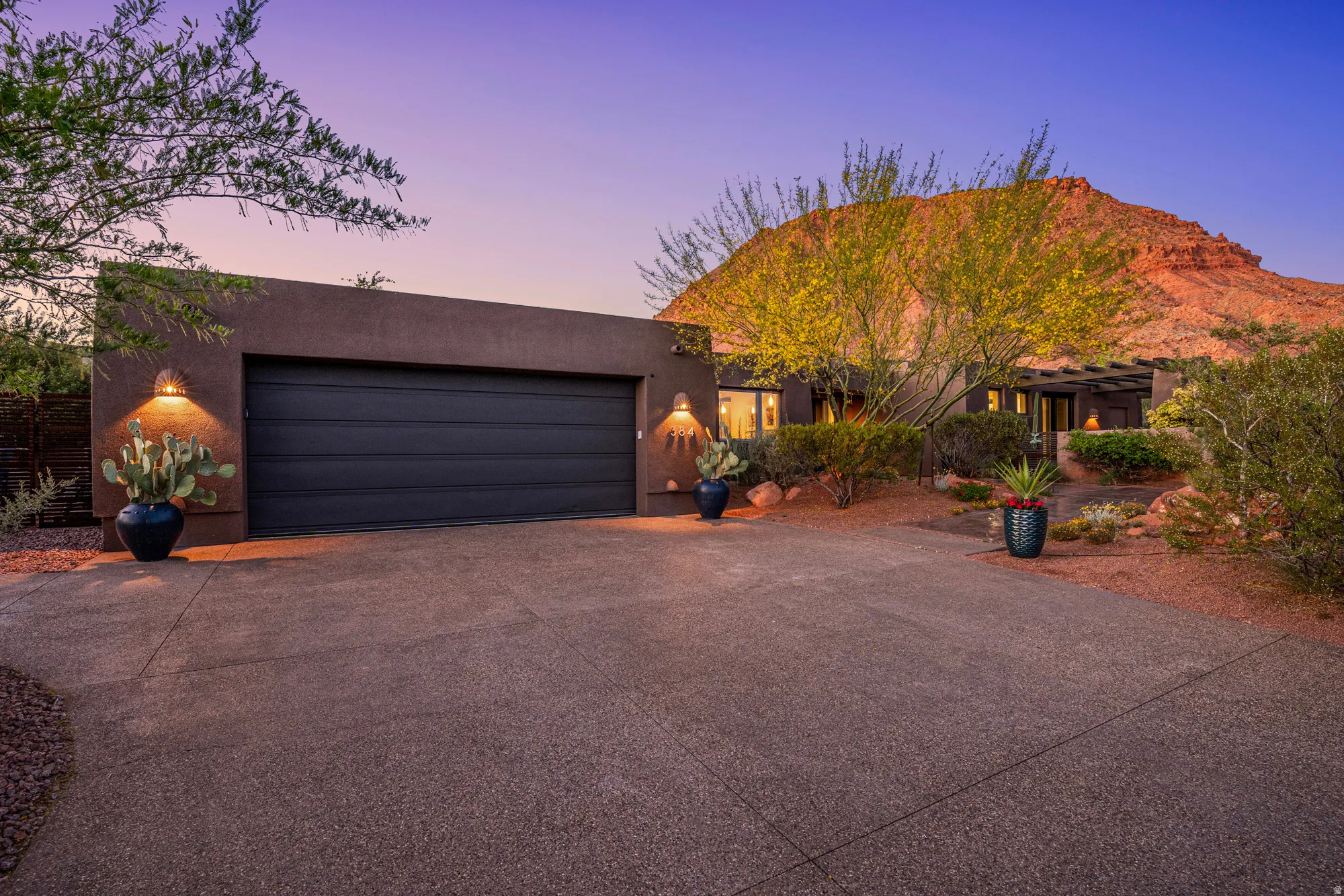 Stucco exterior with a two-car garage and integrated outdoor lighting