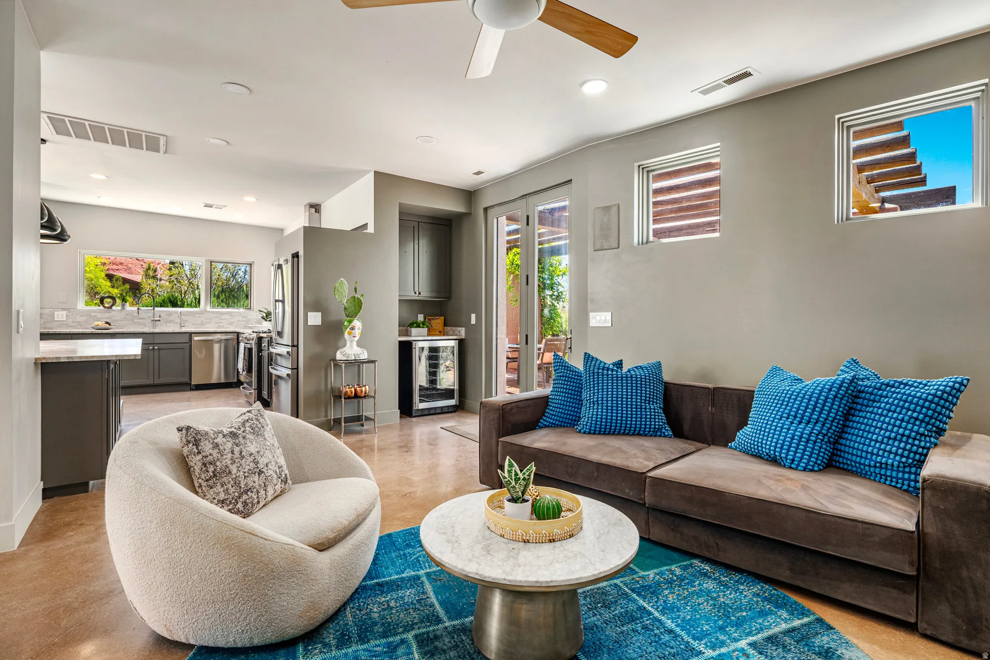 Open-concept living area featuring light gray walls, recessed lighting, a ceiling fan, and concrete-finish flooring