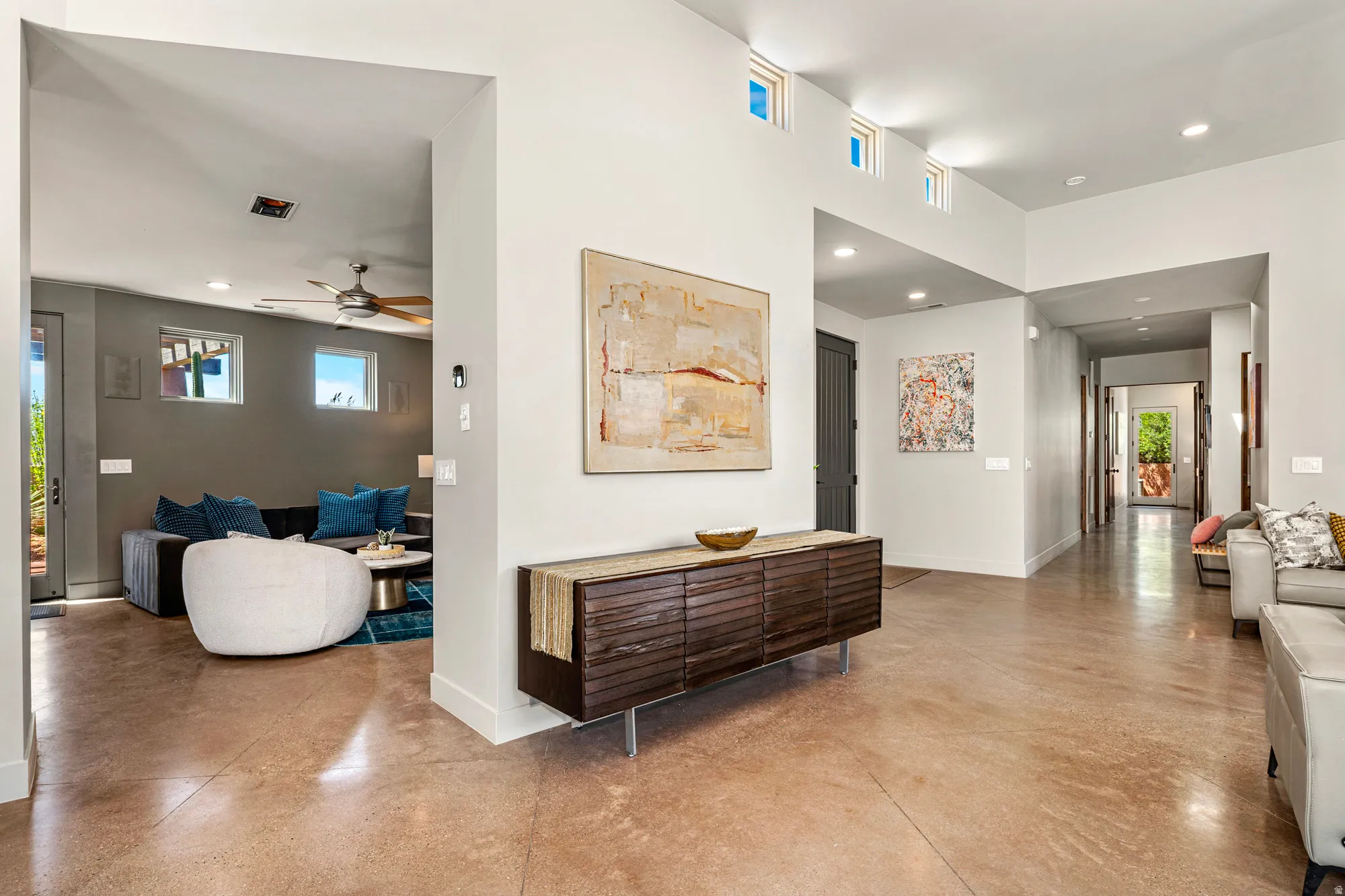 Entryway featuring polished concrete flooring, a spacious hallway, recessed lighting, and high ceilings with multiple clerestory windows