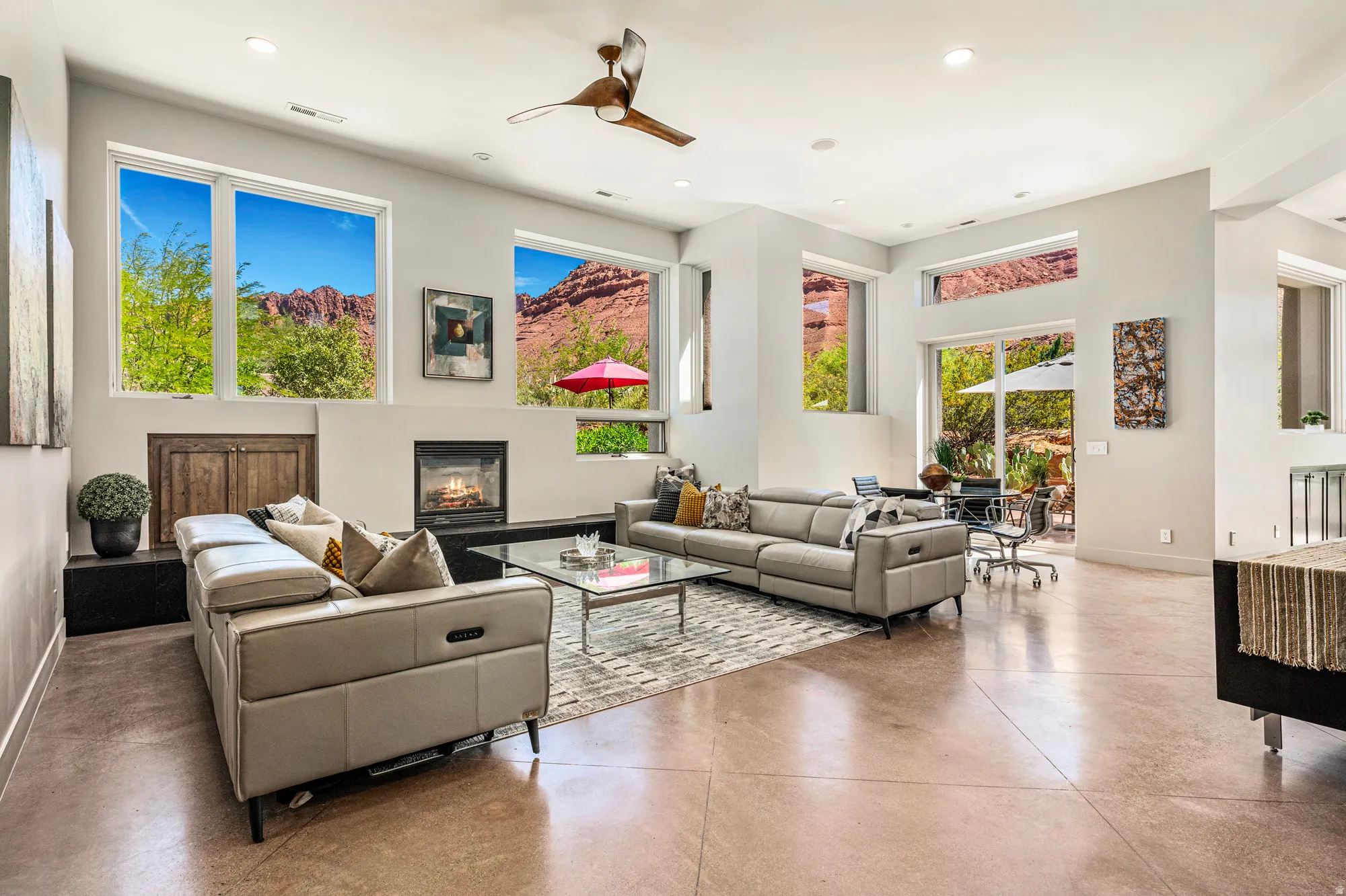Expansive open-concept living area featuring high ceilings, polished concrete flooring, and a contemporary fireplace