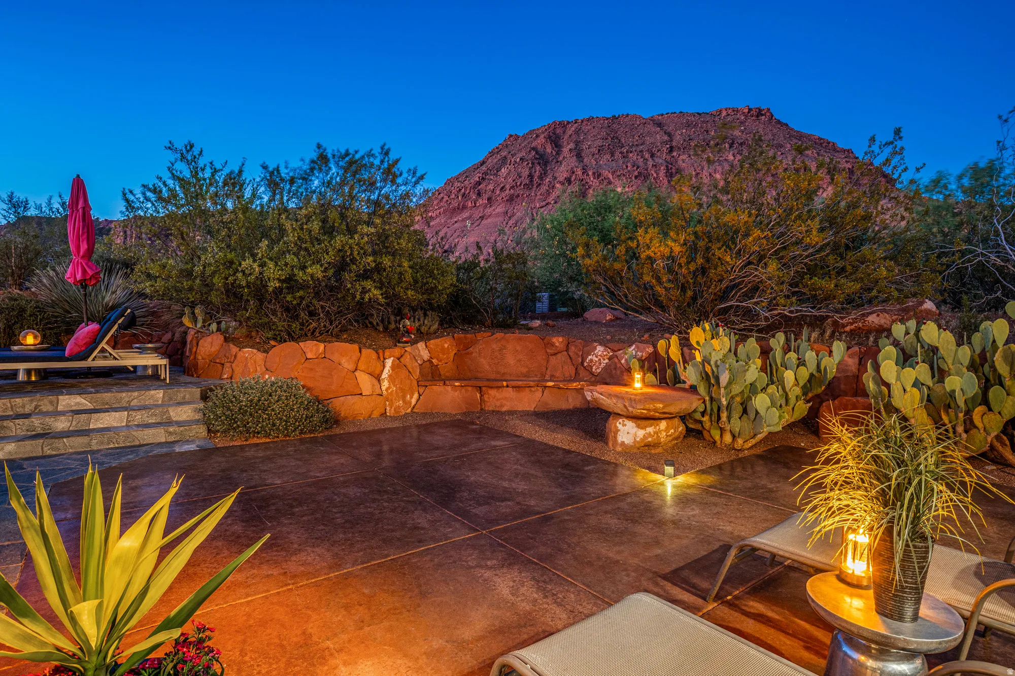 Expansive patio featuring a concrete surface, stone retaining wall, and desert landscaping