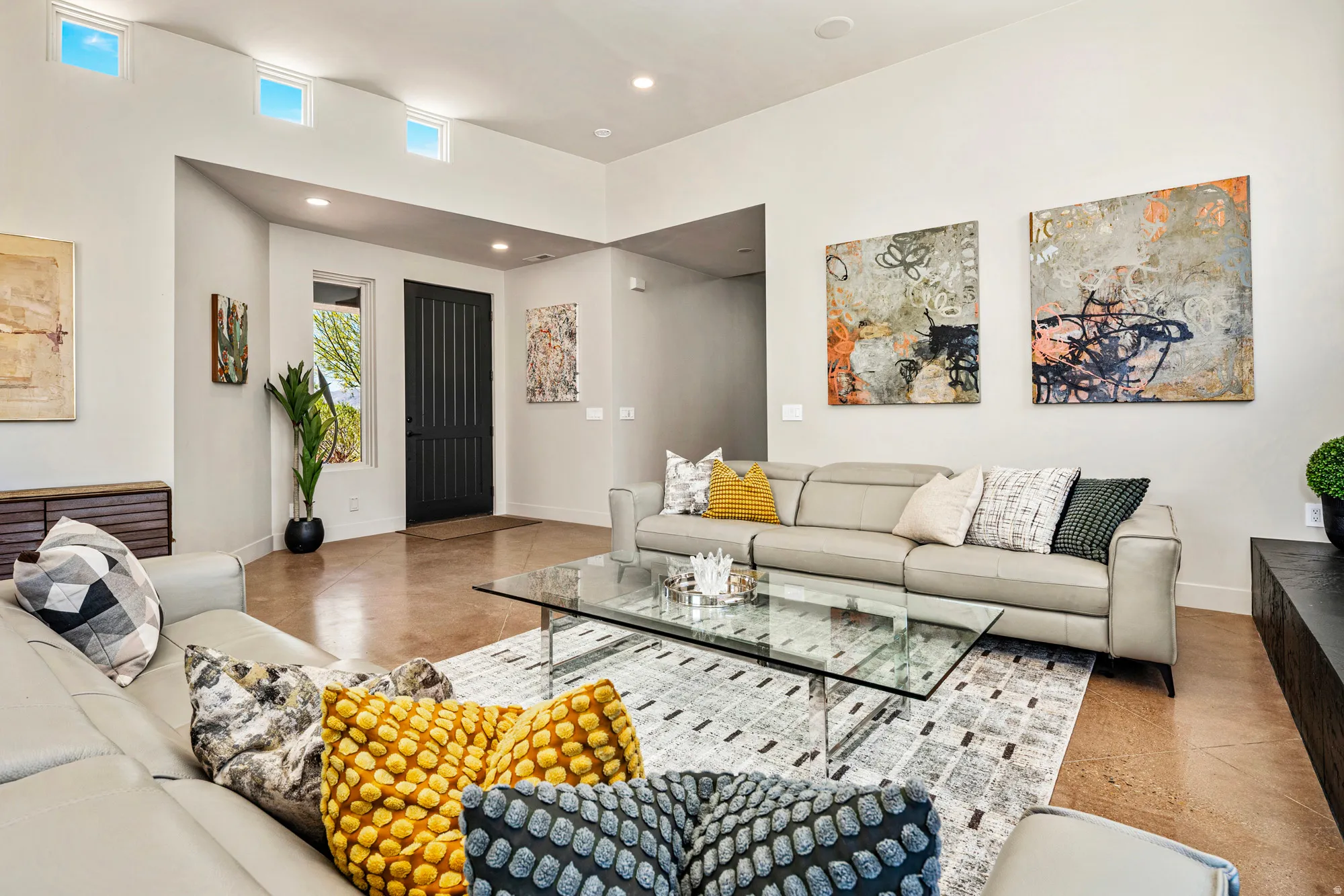 Open-concept living area with high ceilings, recessed lighting, and transom windows