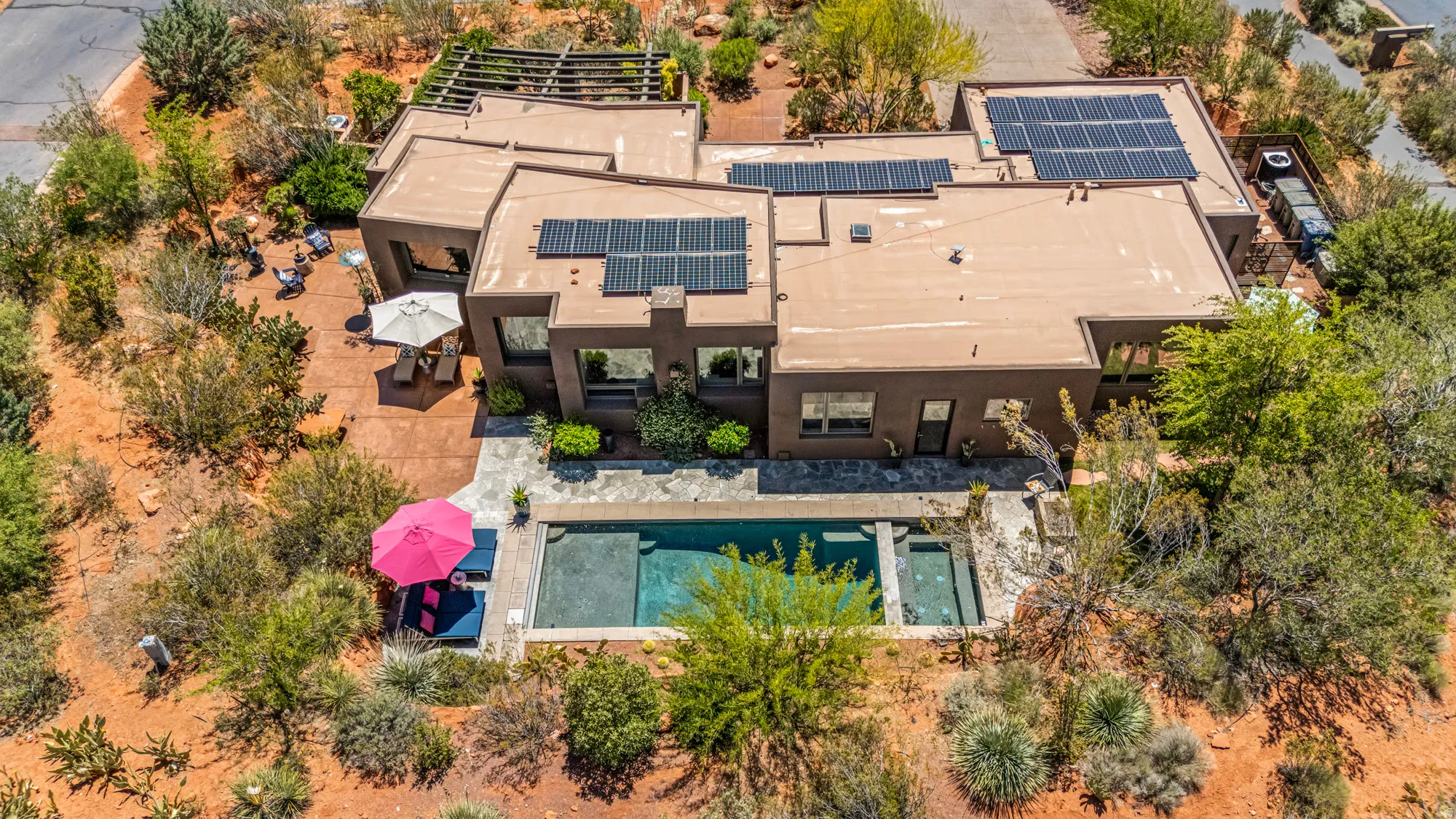 Southwestern-style residence featuring a flat roofline and integrated solar panels