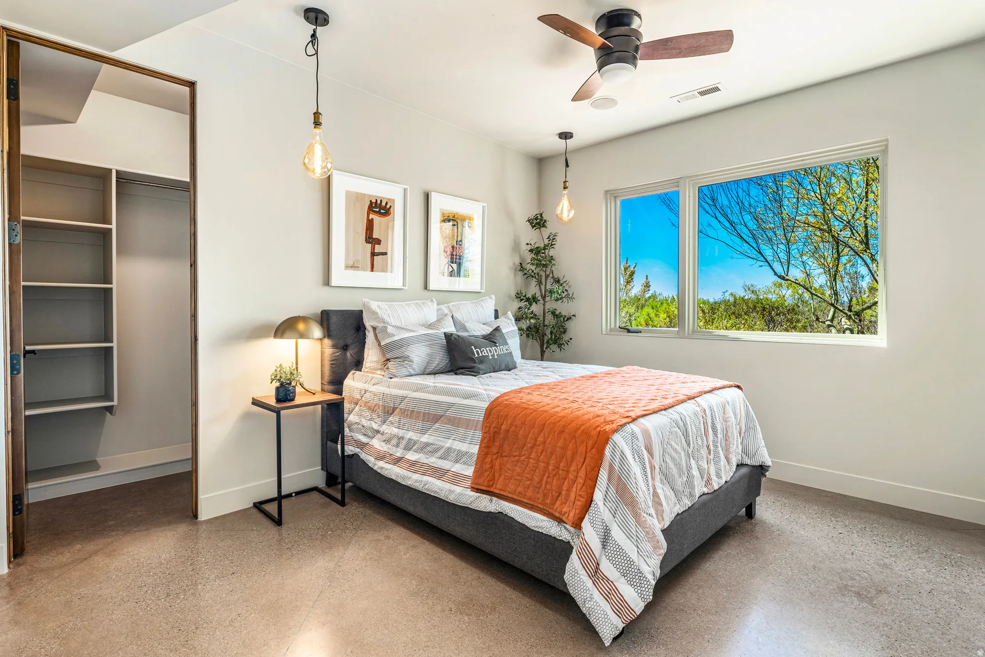 Bedroom featuring polished concrete flooring, a wide window with exterior landscape, a ceiling fan, and an open closet with built-in shelving