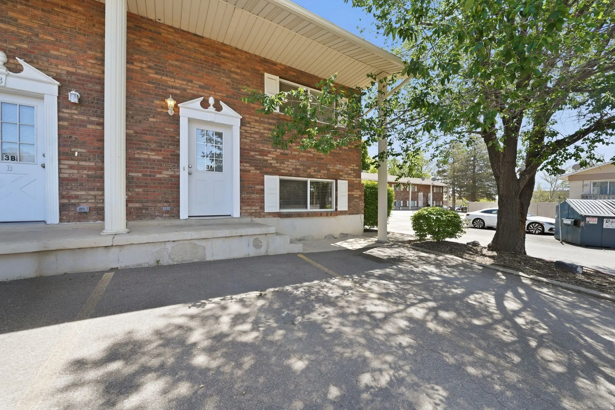 Brick exterior with white trimmed entry doors, featuring transom windows and decorative pediments