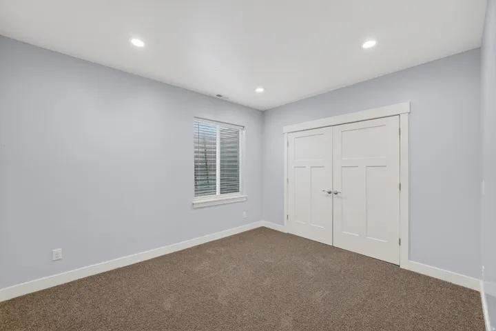 Room featuring light gray walls, plush brown carpeting, and recessed lighting
