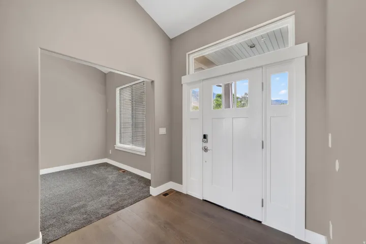 Grand entry featuring a white paneled door with glass inserts, transom window, and sidelights