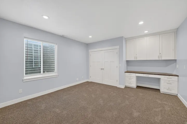 Spacious room featuring light blue walls and neutral carpeting