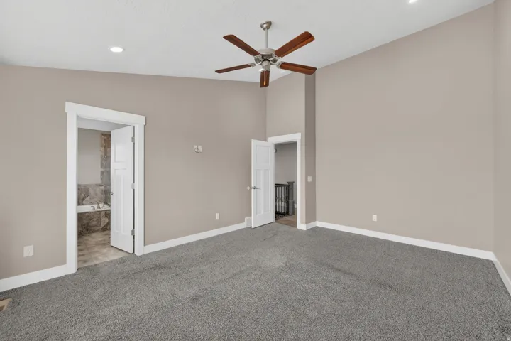 Spacious room featuring vaulted ceilings, recessed lighting, and a ceiling fan