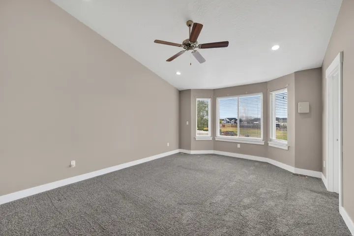 Room featuring a vaulted ceiling and a bay window configuration with multiple casement windows
