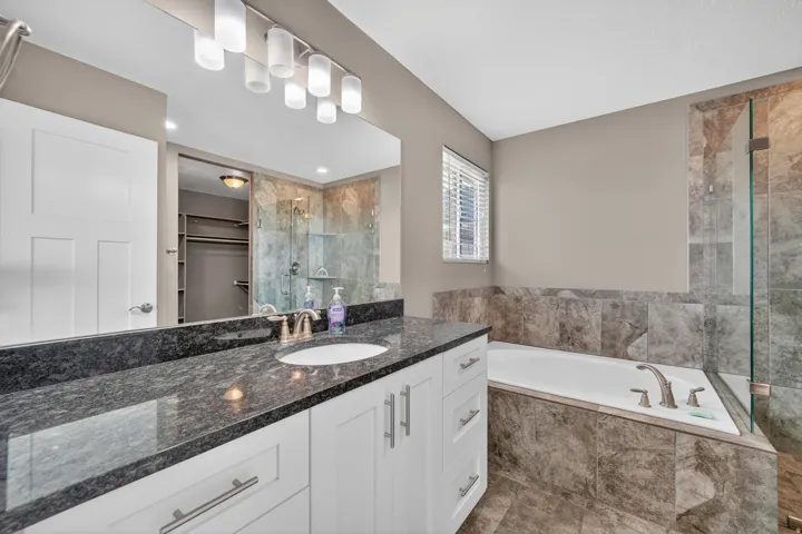 Modern bathroom featuring a single vanity with a dark speckled countertop and undermount sink