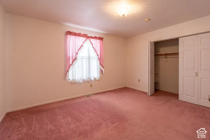 Room featuring wall-to-wall carpeting, a window with natural light, and a ceiling-mounted light fixture