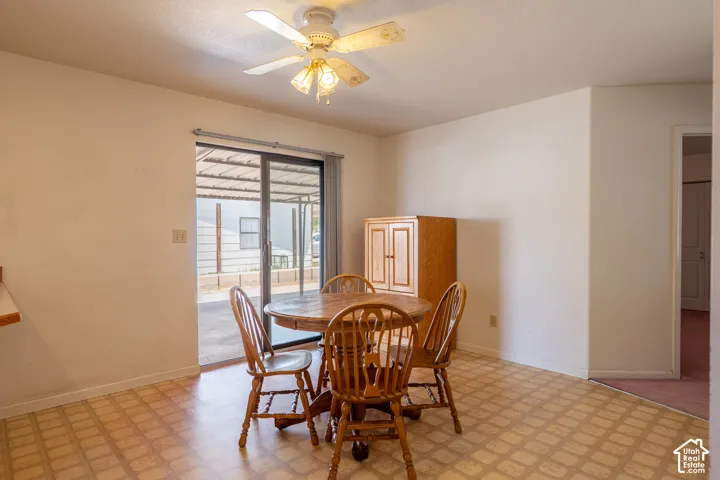 Dining area with patterned flooring, ceiling fan, and sliding glass door access to a covered patio