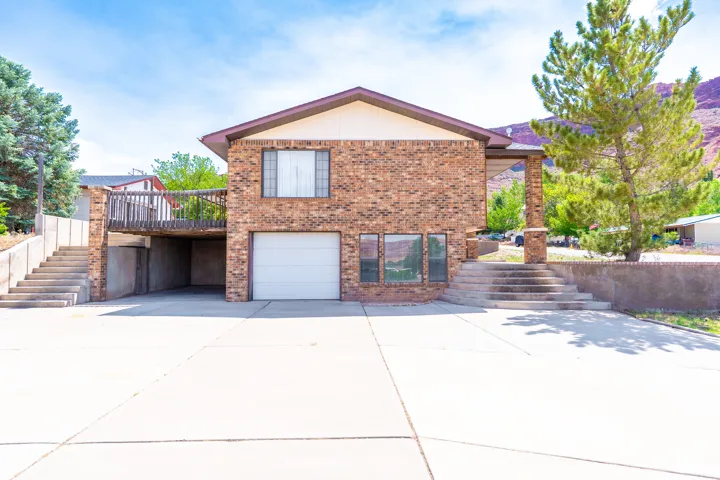 Brick facade residence with a prominent attached garage and a concrete driveway