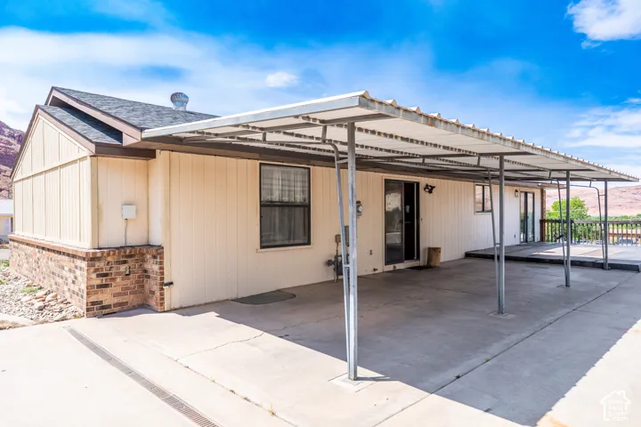 Expansive concrete patio with a full-length metal carport structure