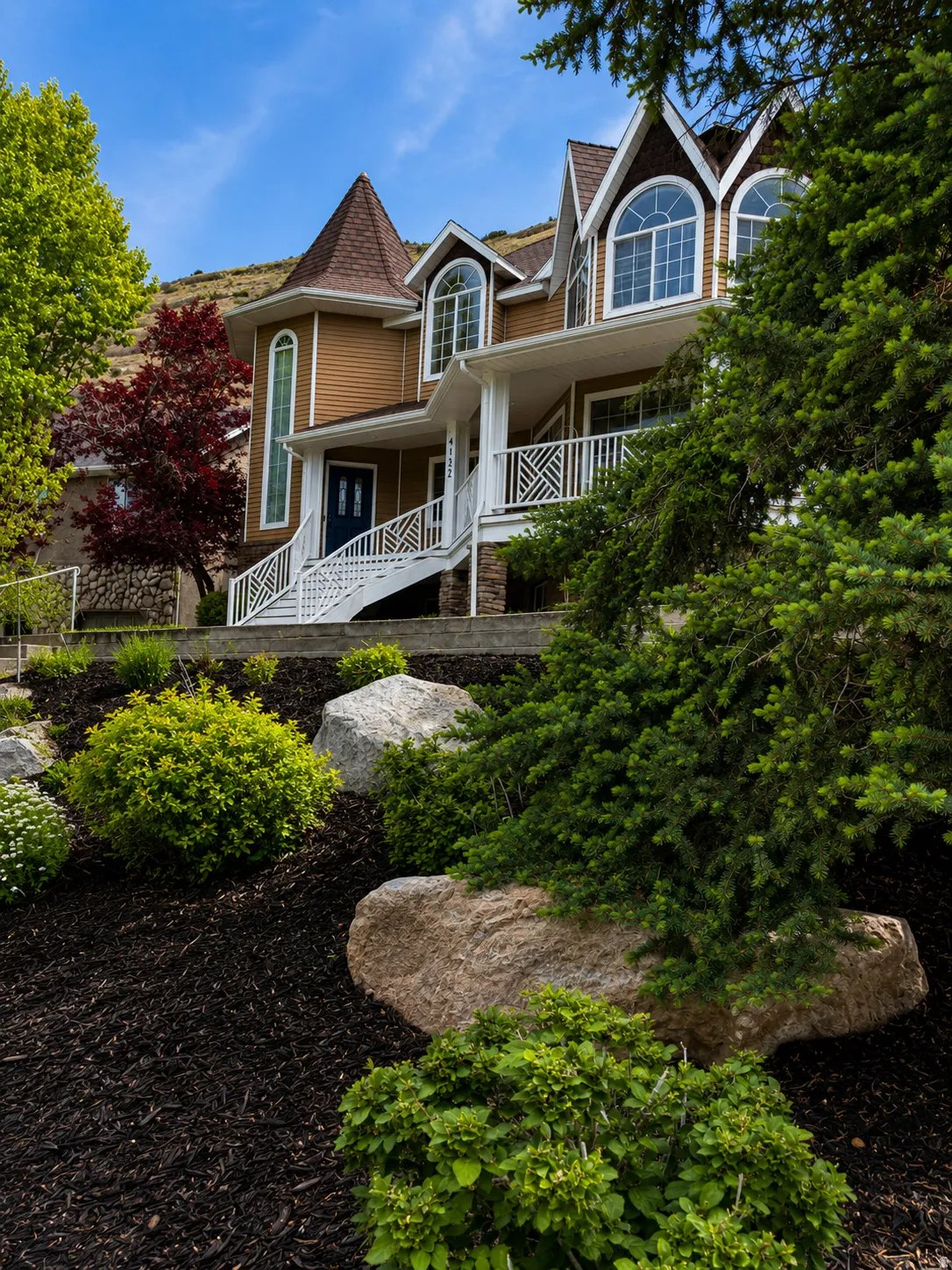 Distinctive residence featuring a prominent turret, arched windows, and a welcoming front porch with white railings