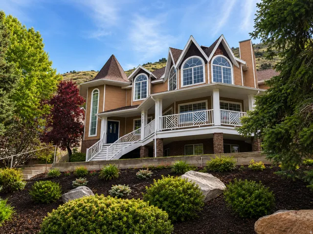 Multi-level residence featuring a prominent turret and a covered porch with white railings