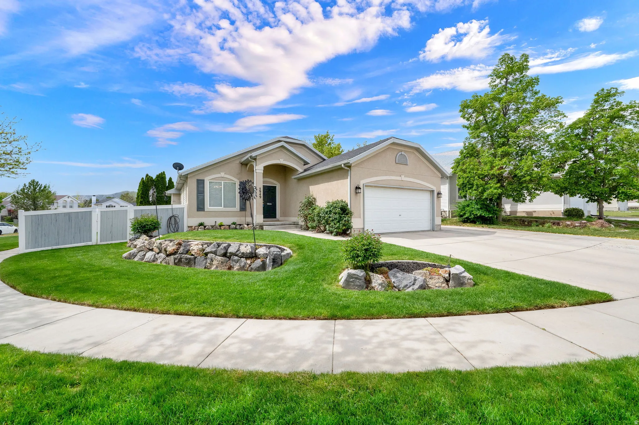Stucco exterior with an arched entry, an attached two-car garage, and a concrete driveway