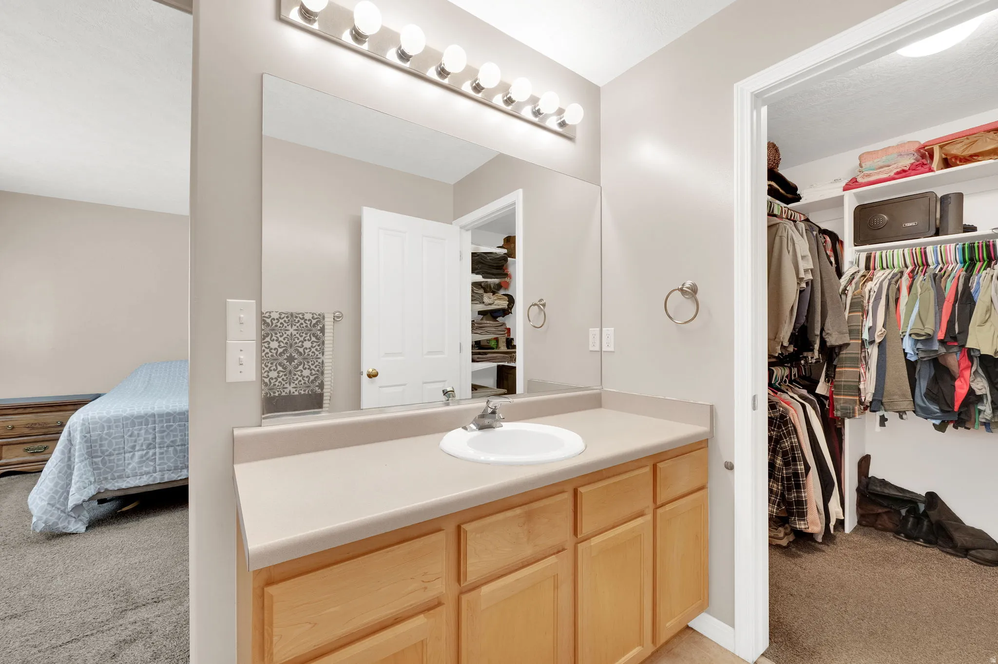Bathroom vanity with a single basin sink and light wood-finish cabinetry