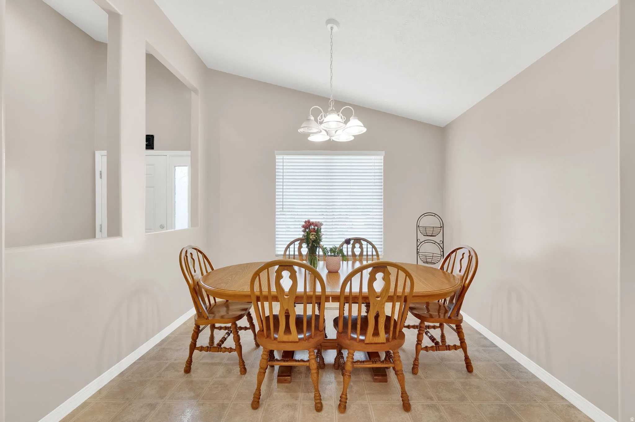 Dining space featuring a vaulted ceiling and tile flooring
