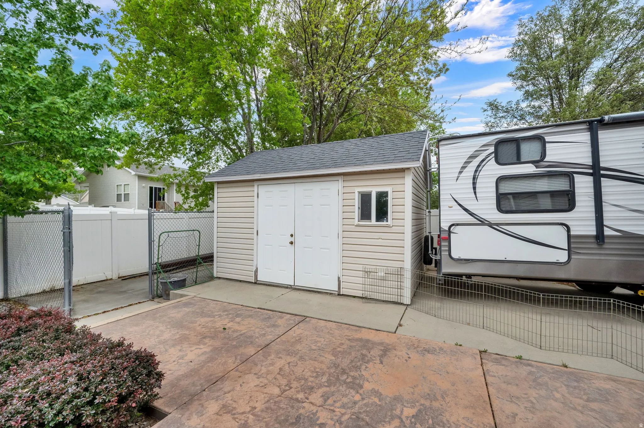 Storage shed with dual entry doors and a window, situated on a concrete pad