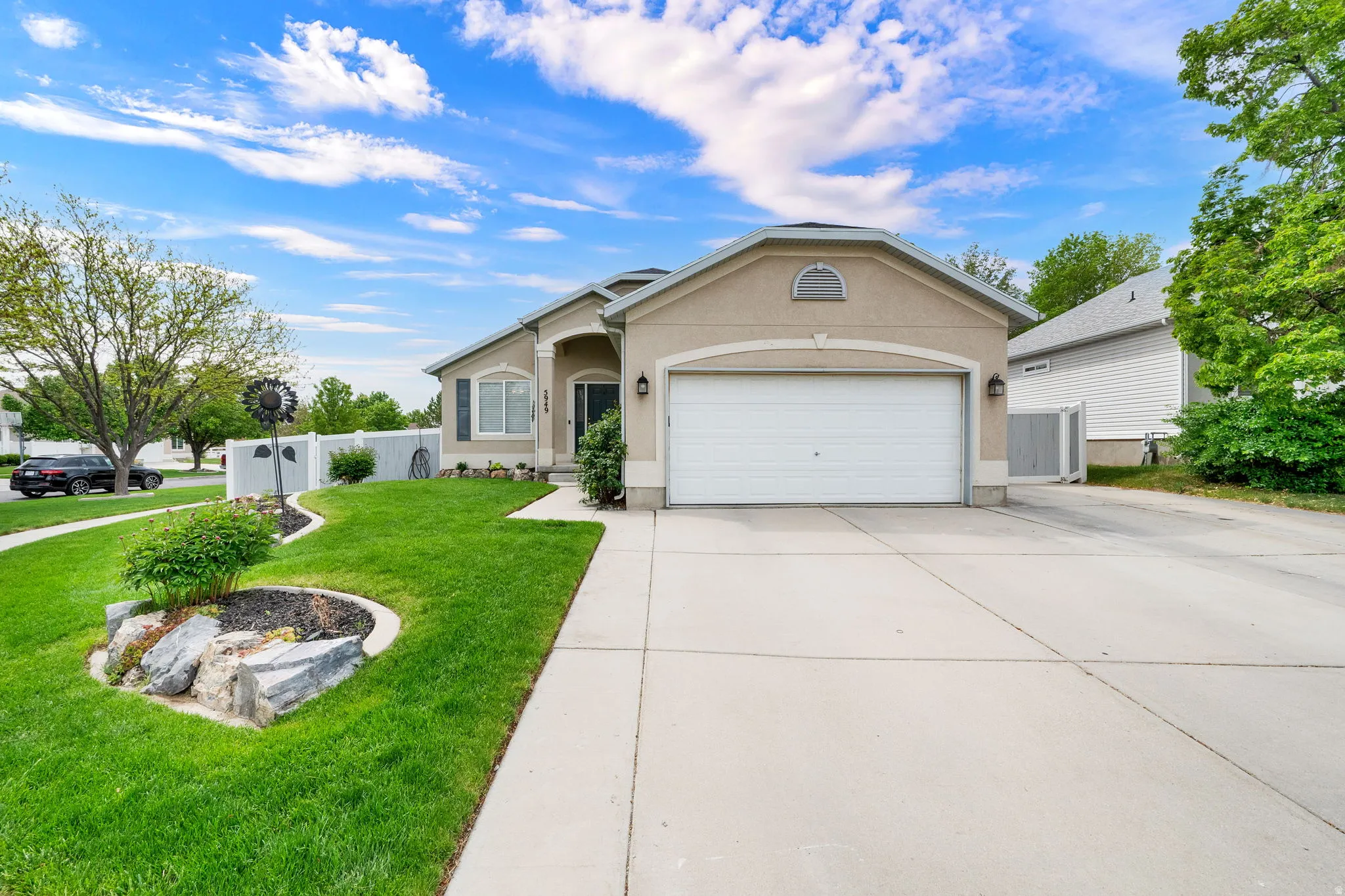 Stucco exterior with an attached two-car garage, concrete driveway, and front walkway