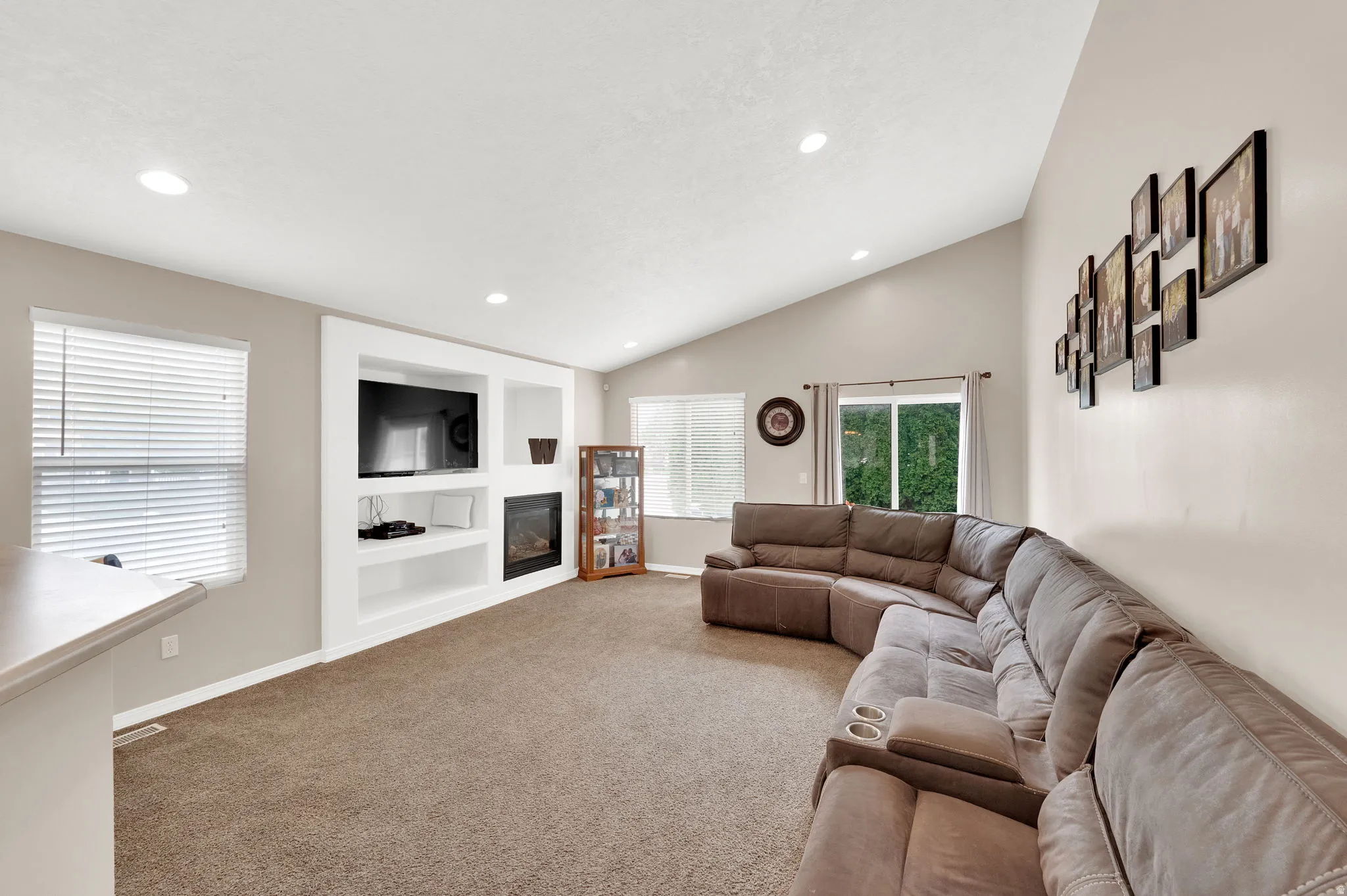 Living area featuring a vaulted ceiling with recessed lighting