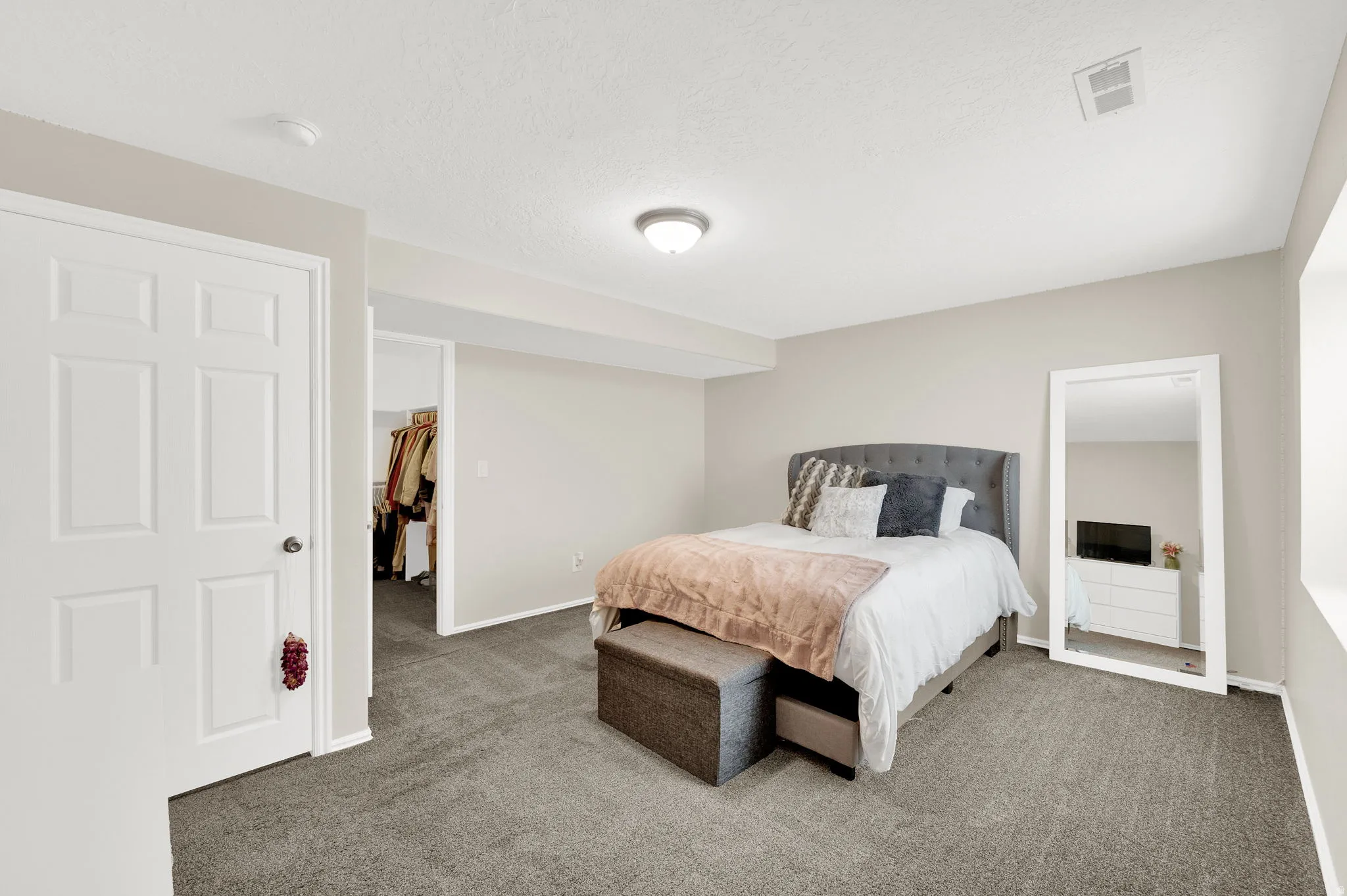 Carpeted room featuring light neutral walls and a paneled white door